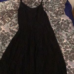 A black dress with a floral pattern of holes